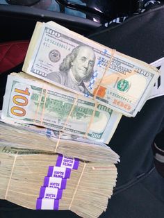 two stacks of money sitting on top of each other in the back seat of a car