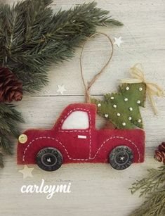 a red truck ornament hanging from a christmas tree