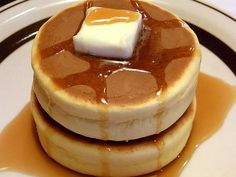 a stack of pancakes covered in caramel syrup and butter on top of a white plate