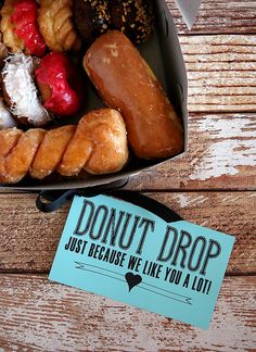 a box filled with donuts and pastries on top of a wooden table