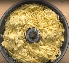 spaghetti being cooked in a pan on top of a stove burner with the lid down