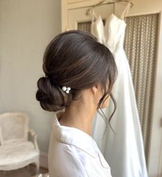 a woman is looking at her wedding dress on the hanger in front of her