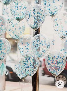 blue and white confetti - filled balloons in front of a storefront window