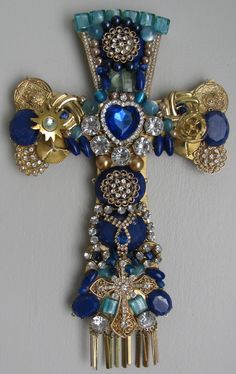 a blue and gold cross brooch with jewels