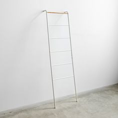 a ladder leaning against a white wall in an empty room