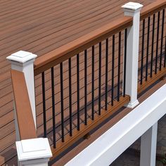 a white bench sitting on top of a wooden deck next to a fenced in area