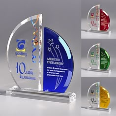 four different awards are shown in three different colors and sizes, each with a glass base