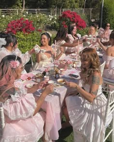 a group of women sitting at a table with plates and cups in front of them