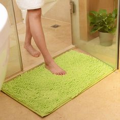 a person standing on a bathroom rug in front of a shower