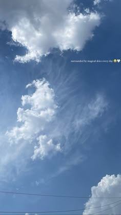 the sky is filled with white clouds and power lines in front of blue cloudy skies