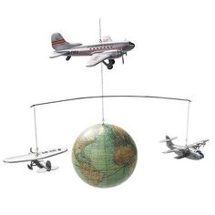 three model airplanes are connected to a globe