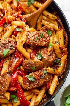 a skillet filled with pasta and meat covered in marinara sauce, garnished with parsley