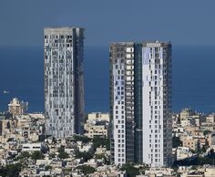 two tall buildings in front of the ocean