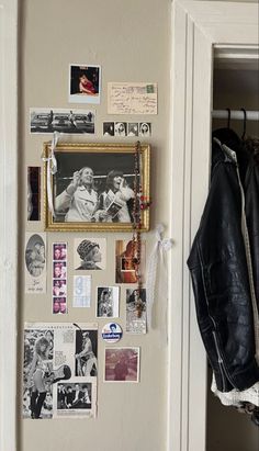 a coat hanging on the wall next to a jacket rack with pictures and magnets