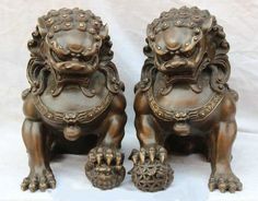 two bronze lions sitting next to each other