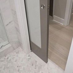 an open door leading to a bathroom with marble flooring