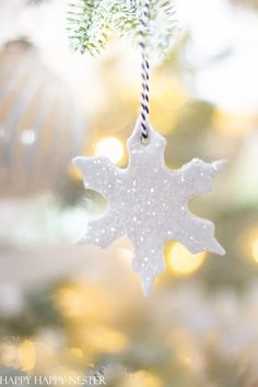 a snowflake ornament hanging from a christmas tree