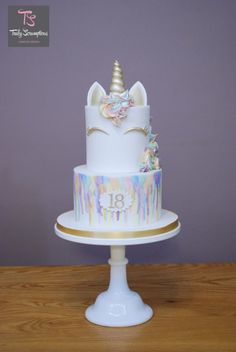 a three tiered cake with an unicorn on top