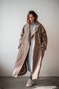 "This double-breasted raglan sleeve trench coat is a wardrobe staple that will elevate every look. Crafted from a quality cotton blend, this minimalist plaid coat is an absolute go-to when transitioning seasons. The oversized longline silhouette with broad lapels and spacious pockets easily matches different styles, be it your formal office attire or a laid-back everyday outfit. The raglan sleeves give you some more room for the shoulders, making this fit suitable for men too. This maxi coat comes without a lining, but every inner seam is carefully covered with binding to give them extra reinforcement and make the coat last longer. If you are looking for a piece that you can wear many seasons in the future, this is the one that you should add to your multi-purpose wardrobe.  WHY PATIS PROJ Checked Trench Coat Outfit, Check Trench Coat Outfit, Long Over Coat Women, Over Sized Trench Coat, Long Check Coat Outfit, Womens Overcoat Outfits, Long Coat Outfit Summer, Check Coats For Women, Big Trench Coat Outfit