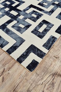 a black and white rug on top of a wooden floor