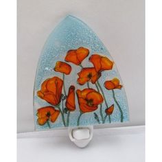 an orange flower is painted on the side of a blue glass object with white handles