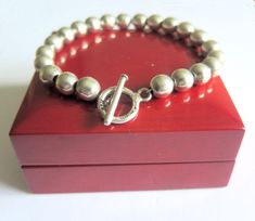 Here we have a superb sterling silver ball bead bracelet that was probably made in the 90s. It is quite heavy weighing 27 grams and the silver ball beads are 8mm wide and thread onto a silver chain.. The bracelet has been finished using a large 14mm diam toggle clasp that is hallmarked sterling and also includes a British Assay Hallmark showing 925 purity. Also, this quality bracelet was made in Mexico.       Bracelet Length 8.5" Inches By 8mm Wide - Stamped Sterling 925 & Mexico Also British Ha Toggle Clasp, Bead Bracelet, Hallmark, Silver Chain, Thread, Beaded Bracelets, Bracelet, Beads, Sterling Silver