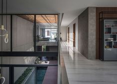 the interior of a modern house with glass walls and floor to ceiling windows that overlook an outdoor swimming pool