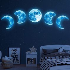 three moon phases glow in the night sky above a child's bedroom with a bed