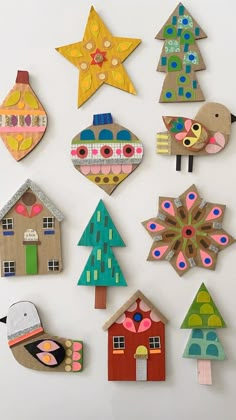 several different types of paper cut outs are arranged on a white surface, each with an ornament in the shape of a house