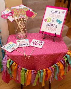 a pink table topped with an umbrella and some cards on it's stand next to a sign that says grand & strokea