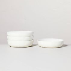 four white bowls sitting next to each other on a table