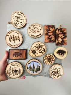 a person holding a piece of wood with different designs on it