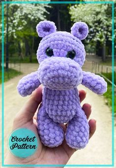 a purple crocheted stuffed animal sitting on top of a hand