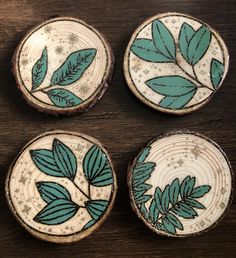 four pieces of wood with leaves painted on them