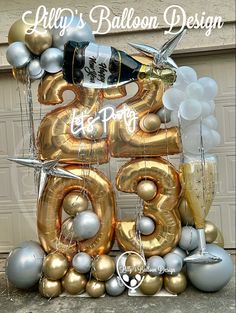 the balloon number is decorated with silver and gold balloons, champagne bottles, and two doves