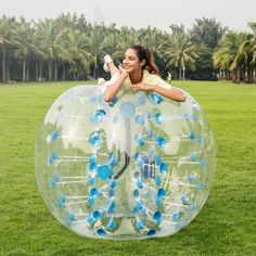 a woman laying on top of an inflatable bubble ball with blue flowers inside