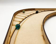 a close up of a wooden train track with green beads on the top and bottom