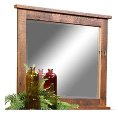 a mirror sitting on top of a wooden shelf next to vases and bottle bottles