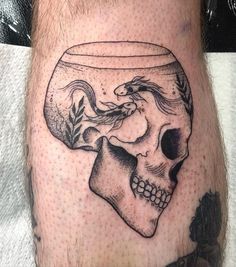 a man's leg with a tattoo on it and a skull in the bowl