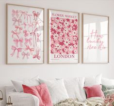 three pink and white wall hangings in a living room