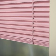 a pink window blind with the blinds pulled down to expose light coming in through it