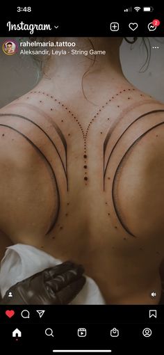 the back of a woman with tattoos on her upper and lower back, which are dotted in dots