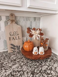 some pumpkins are sitting on a wooden tray in the corner of a kitchen counter