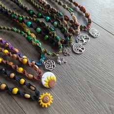 a collection of beaded necklaces on a wooden table with beads and charms hanging from them