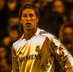 a soccer player is standing in front of an audience with his hands on his hips