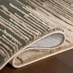 a close up of a rug on the floor with a wooden floor in front of it