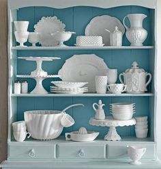 a blue china cabinet filled with white dishes