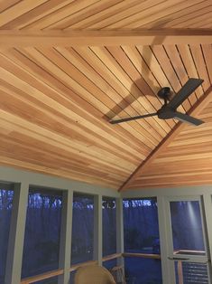 a ceiling fan mounted to the side of a wooden roof