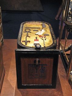 an old fashioned wooden box with keys on it's lid sitting on a table