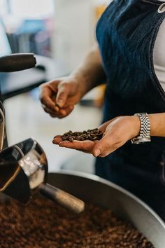 a person holding some coffee beans in their hands